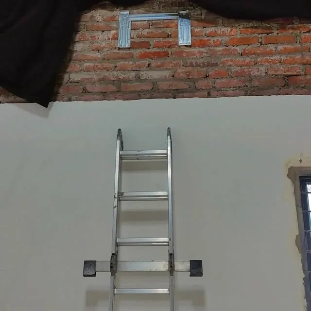 Escalera y soporte metálico listo en una pared de ladrillo antes de montar el equipo